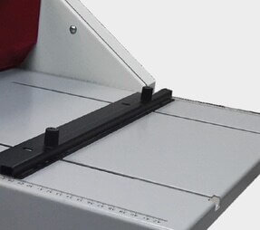 Adjustable paper stops enable angled direction towards the crease blade.