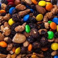 Close-up of a snack mix with nuts, raisins and colorful candy pieces