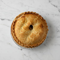 Whole Brown's Market Crispy Apple Pie with golden top crust in a foil pie pan, viewed from above