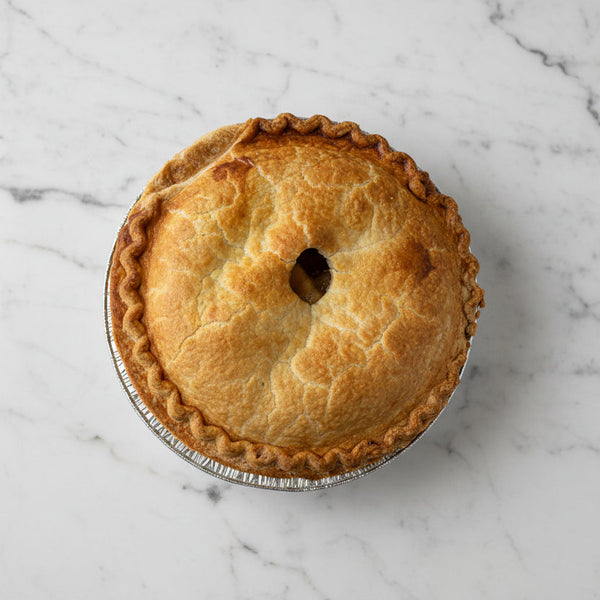 Whole Brown's Market Crispy Apple Pie with golden top crust in a foil pie pan, viewed from above