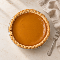 Whole Brown’s Market Sweet Pumpkin Pie on a neutral table with linen and a dessert fork.
