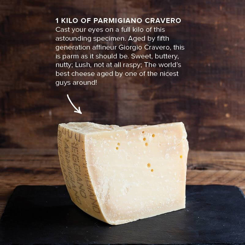 Approximately one-kilo wedge of Cravero Parmigiano Reggiano pictured on a dark serving slate