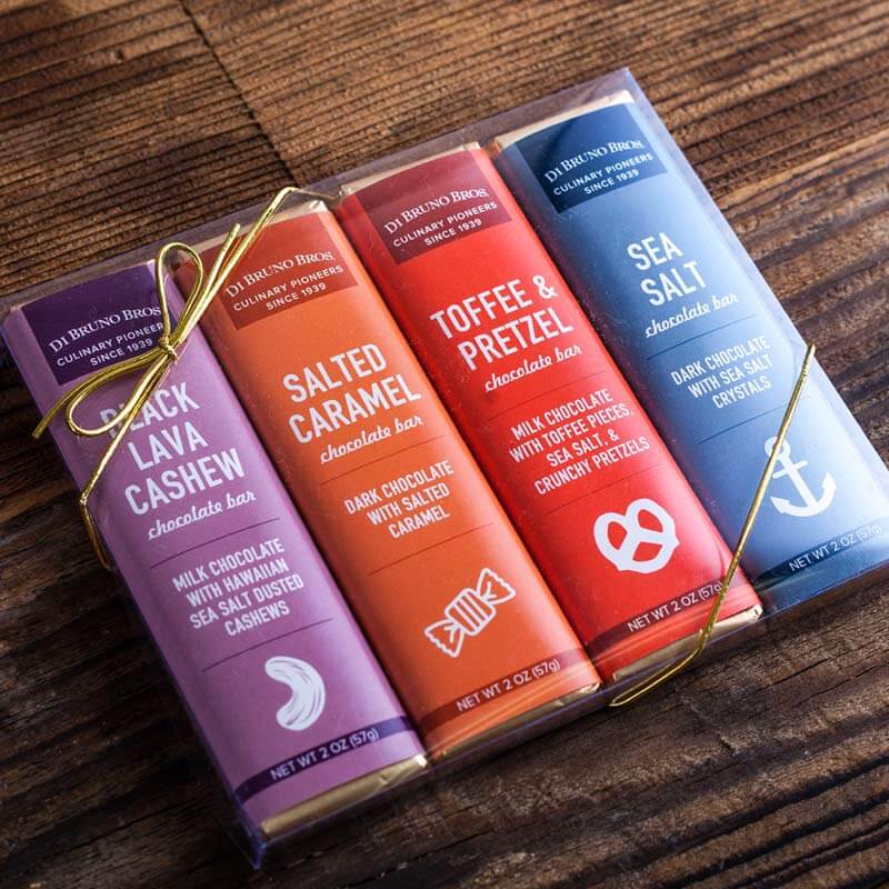 Illustrative display of four Di Bruno Bros. chocolate bar flavors: salted caramel, toffee pretzel, roasted almond, and sea salt