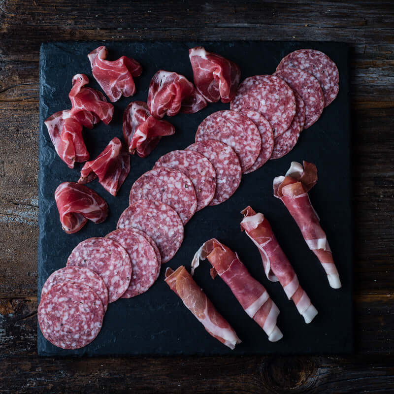 Antipasto serving arrangement with cured meats and accompaniments