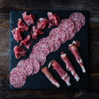 Antipasto serving arrangement with cured meats and accompaniments