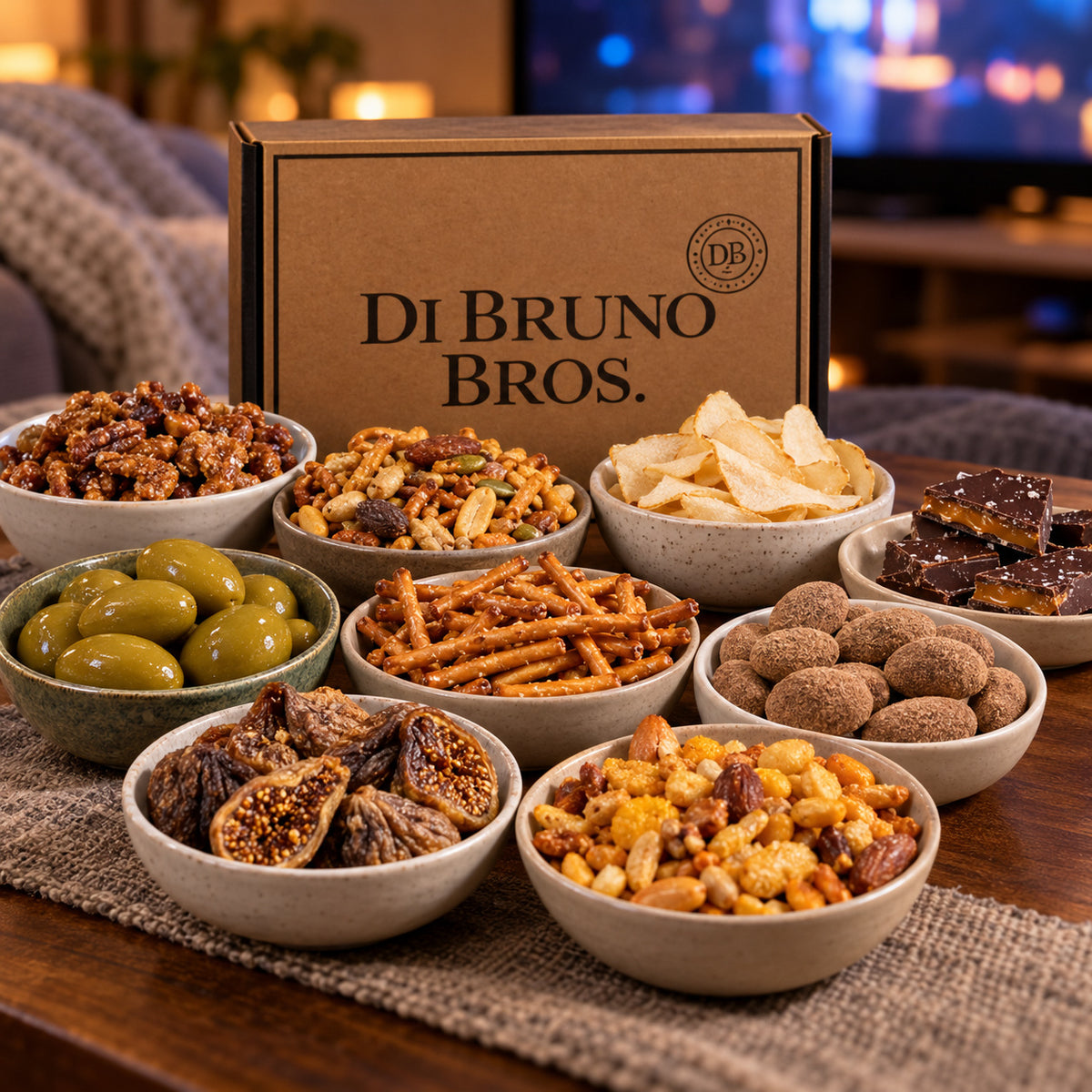 Binge Watch Gift Box snacks arranged for a movie night with chocolate, pretzels, olives, fruit, and snack mixes