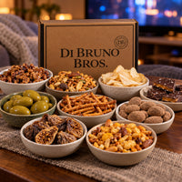 Binge Watch Gift Box snacks arranged for a movie night with chocolate, pretzels, olives, fruit, and snack mixes
