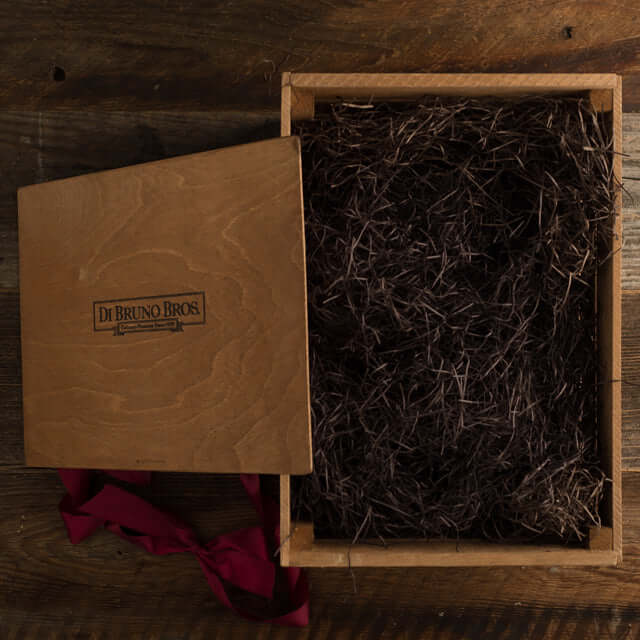 Open Di Bruno Bros. branded wooden display crate with packing material and lid