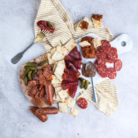 Styled charcuterie platter with meats, cheese and crackers; additional foods shown may not be included