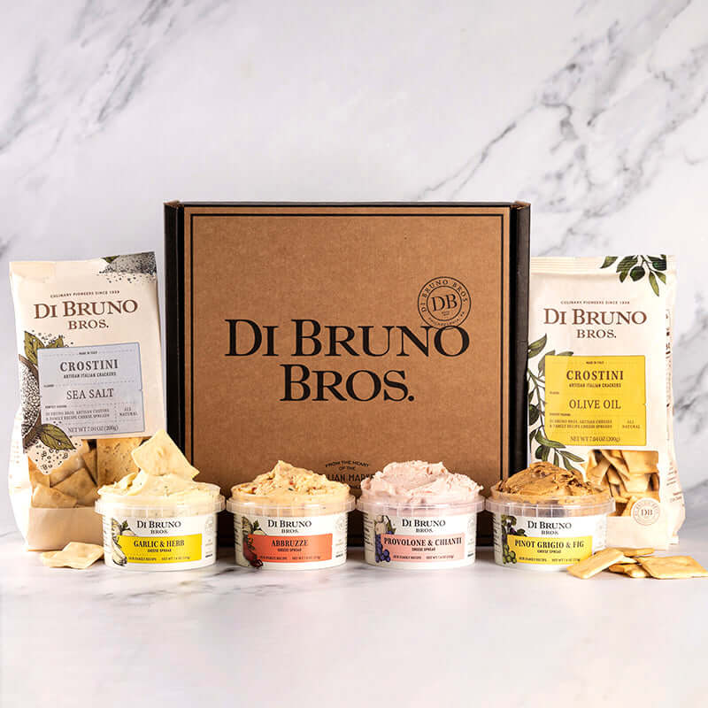 Di Bruno Bros. Cheese Spread Sampler gift box pictured with four example cheese spreads and two bags of crostini