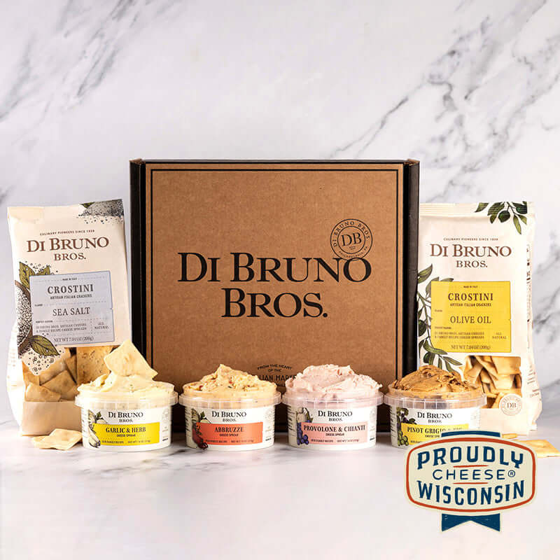 Di Bruno Bros. gift box with two crostini bags, four example cheese spreads, and a Proudly Wisconsin Cheese badge