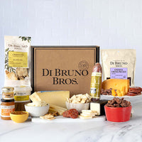 Styled Di Bruno Bros. Perfect Pairings gift box with cheeses, salami, crostini, spread, jam, honey, and nuts
