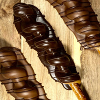 Hand-dipped milk and dark chocolate pretzels with layered chocolate and caramel toppings