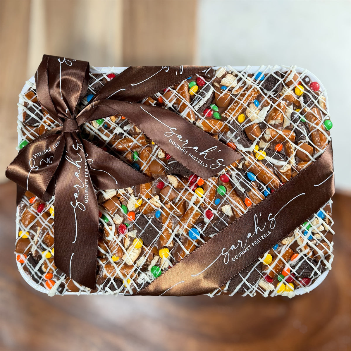 Gluten-free chocolate bark platter topped with caramel, pretzels, chocolate cookies and colorful mini candies
