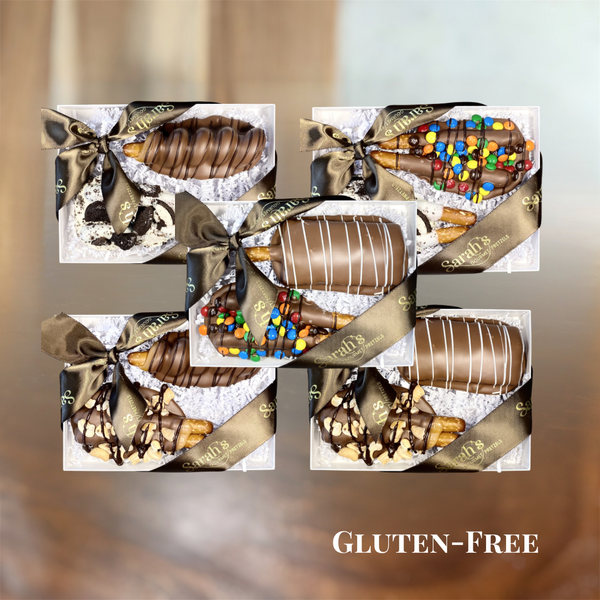 Five Sarah’s Gourmet Pretzels gluten-free gift boxes displaying 10 chocolate-covered pretzel rods in caramel, cookie, candy, peanut butter and cashew flavor pairings