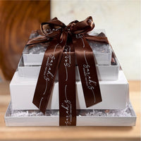 Front view of Sarah’s Gourmet Pretzels stacked chocolate and snack gift tower tied with branded brown ribbon